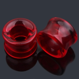 Gros plan d'écarteurs d'oreilles rouges translucides à double évasement avec reflet noir