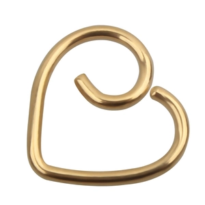 Macro detail of golden heart-shaped ear cuff with smooth polished finish on white background
