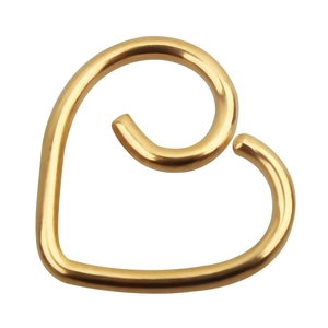 Detail shot of heart-shaped gold ear clip with smooth mirror-polished metallic finish