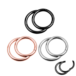 Detailed close-up of polished hinge clicker rings in black, rose gold, and silver steel