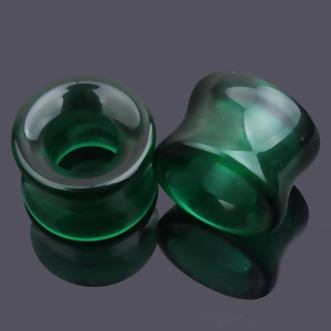 Détail d'écarteurs en verre vert foncé translucide avec un design lisse en selle