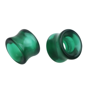 Vue macro d'une paire de tunnels d'oreilles évasés en verre vert translucide