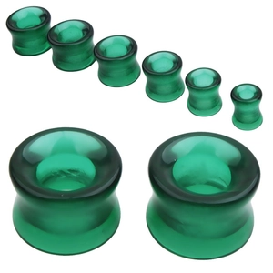 Gros plan d'écarteurs d'oreilles en verre vert translucide de différentes tailles