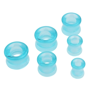Vue macro d'écarteurs d'oreilles évasés en verre bleu de différentes tailles