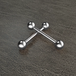Detailed view of two silver stainless steel barbell piercing jewelry sets on dark leather
