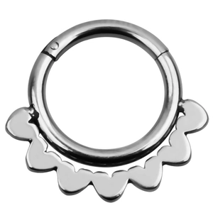 Close-up of silver piercing jewelry with decorative scallop edge and clicker hoop
