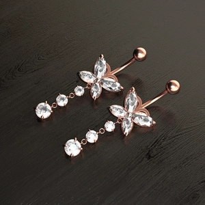 Detalle de piercings de ombligo de mariposa en oro rosa con piedras de circonita brillante