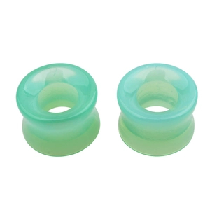 Détail macro d'écarteurs d'oreilles creux en verre vert menthe avec bords évasés