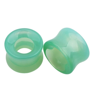 Détail des écarteurs d'oreilles en verre creux vert clair avec surface polie