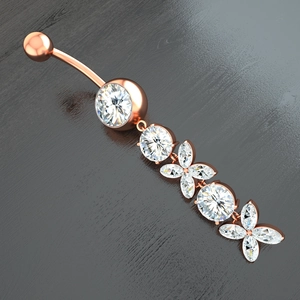 Macro detail of rose gold navel ring with marquise zircon flower on wood surface