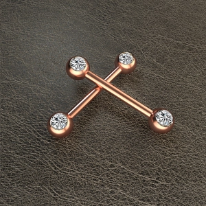 Detailed macro view of rose gold barbell piercings with bezel-set round clear gemstones