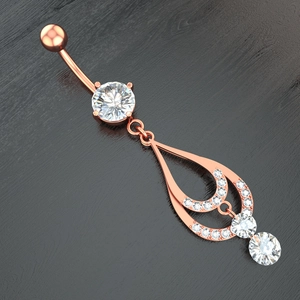 Macro detail of rose gold belly button ring with sparkling zircon in teardrop pendant