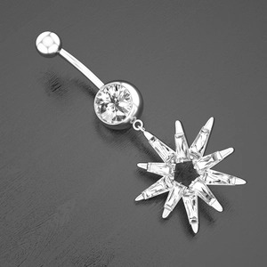 Macro shot of a silver navel ring with baguette-cut starburst pendant on grey wood