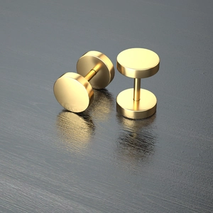 Detalle de pendientes de acero inoxidable dorado con forma de pesa sobre madera