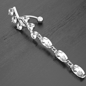 Macro detail of silver navel ring featuring marquise-cut stones and curved drop design