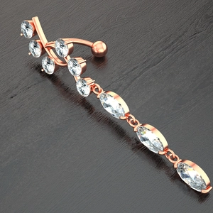 Detailed macro view of rose gold navel ring with marquise and round cut cubic zirconia