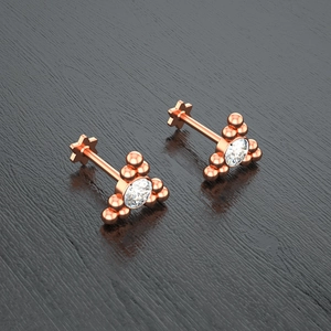 Detailed macro view of rose gold labret studs with zircon stone and star-shaped backings