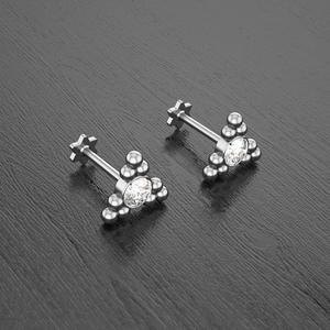 Detailed macro shot of silver surgical steel labret studs with three-ball cluster and zircon