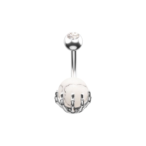 Primer plano de piercing de ombligo punk con garra de hueso plateada y piedra blanca