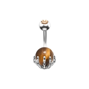 Detalle de piercing de ombligo con garra de mano de calavera y piedra de ojo de tigre natural