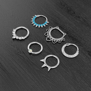 Detailed set of silver stainless steel piercing rings with zircon and blue bead accents