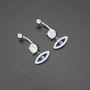 Macro detail of silver evil eye belly rings with sparkling blue and white cubic zirconia