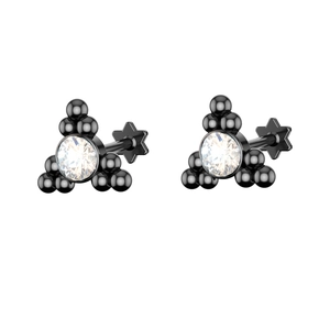 Macro view of black steel piercing studs with three-ball design and clear zircon