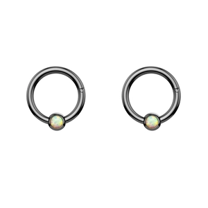 Detailed macro view of black plated stainless steel rings with white opal inlay
