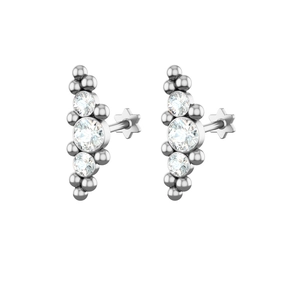 Macro detail of silver labret studs with three stacked gems and star-shaped backings