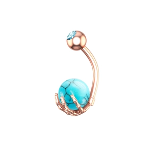 Detalle macro del piercing de ombligo en oro rosa con garra y piedra de turquesa azulada