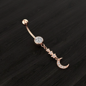 Rose gold moon and stars belly button ring with sparkling zircon stones on wood