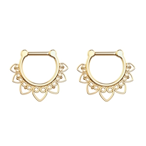 Detail of golden heart-shaped filigree nose rings with bohemian engraving on white background
