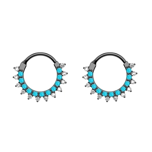 Detail of black stainless steel nose rings with blue beads and clear crystals set in waves