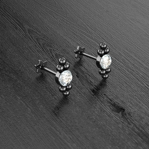 Detail of black PVD stud earrings with clear zircon and star-shaped flat back closure