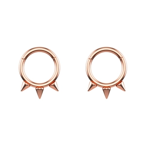 Close-up of rose gold hinged hoops with triple cone spikes for piercings