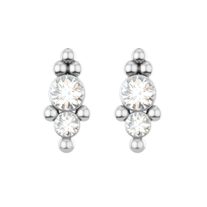 Detail of silver piercing studs with dual stacked cubic zirconia and metal bead accents