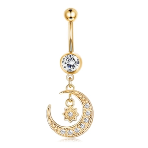 Close-up of golden belly button ring with moon and star zircon pendant details