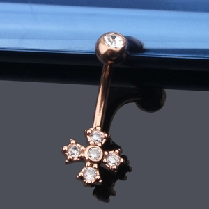 Makroaufnahme von Bauchnabelpiercing in Roségold mit Zirkonia-Kreuzanhänger