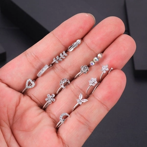 Gros plan de pinces à nez argentées en zircon avec motifs de cœur, lune et papillon