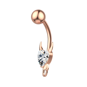 Detail of rose gold belly button ring with heart-shaped zircon and devil horn design
