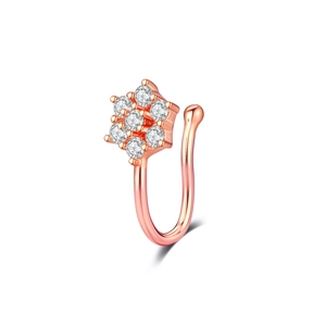 Détail d'un anneau de nez en forme de U en or rose avec sept zircons blancs en fleur