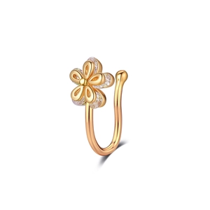 Détail d'un clip de nez doré en forme de fleur avec zircons et design en U poli