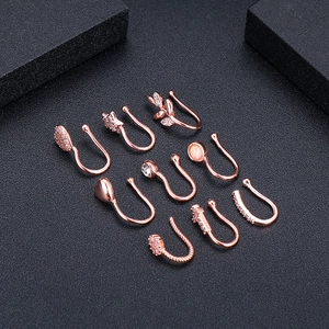 Set di 9 anelli per naso in oro rosa non perforanti con zirconi e opale su fondo nero