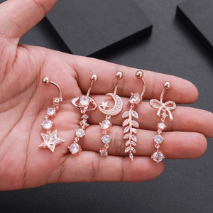 Detailed view of five rose gold navel rings with star, moon, and butterfly zircon charms