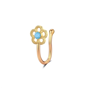 Detail of gold U-shaped non-pierced nose ring with blue gem and flower design