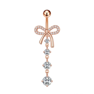 Detail of rose gold belly button ring with zircon bow and four cascading gems