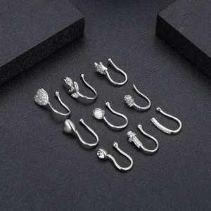 Set di 9 finti piercing al naso argentati con design a cuore e stella su sfondo nero