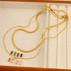 Dettaglio di collana a strati in oro 18K con ciondolo in zircone e portagioie