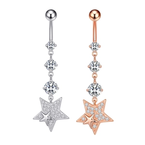 Detail view of silver and rose gold belly rings with sparkling zircon star pendants