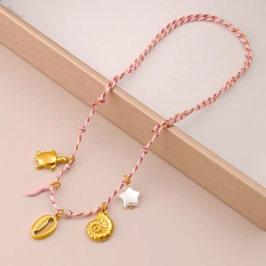 Detalle de collar trenzado rosa de tema marino con colgantes de tortuga y concha